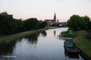 Blick nach Sarrealbe. Man sieht die Kirche und den Saar-Kohlekanal im Dämmerlicht des Abends.