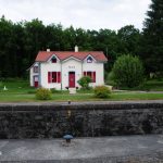 Schleusenhaus 16 am Saar-Kohlekanal. Weiß mit roten Fenstern und Tür, Ziegeldach.