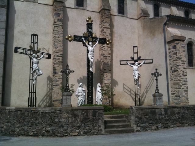 Kreuzigungsszene dreier Kreuze vor Kirchenmauer.