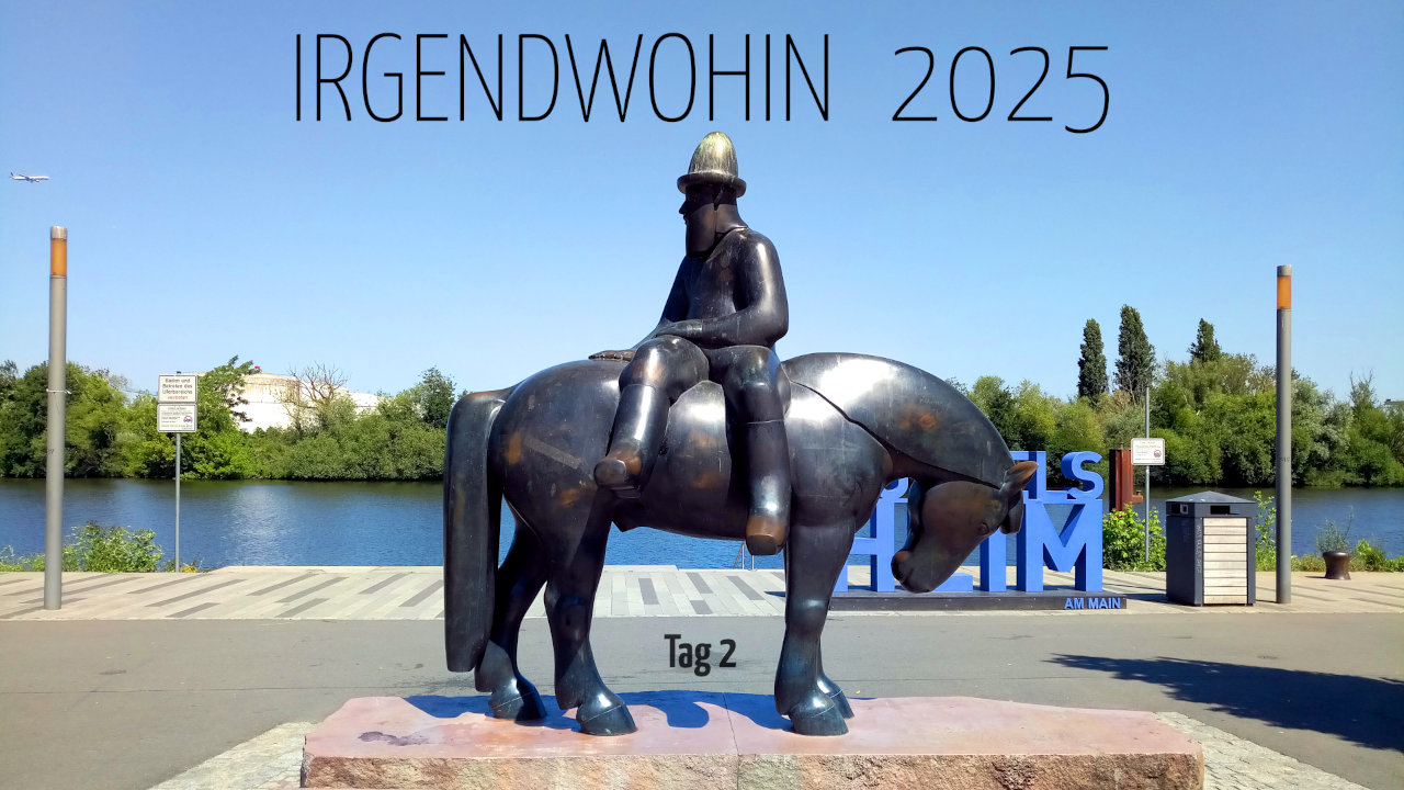 Bronzeskulptur eines Treidelpferd-Reiters am Main. Der Reiter sitzt quer auf dem Rücken. Im Hintergrund der Fluß und auf der anderen Seite grüner Baumbewuchs.